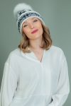 wool hat with fur pom-pom in dark blue Santa deer pattern in white background