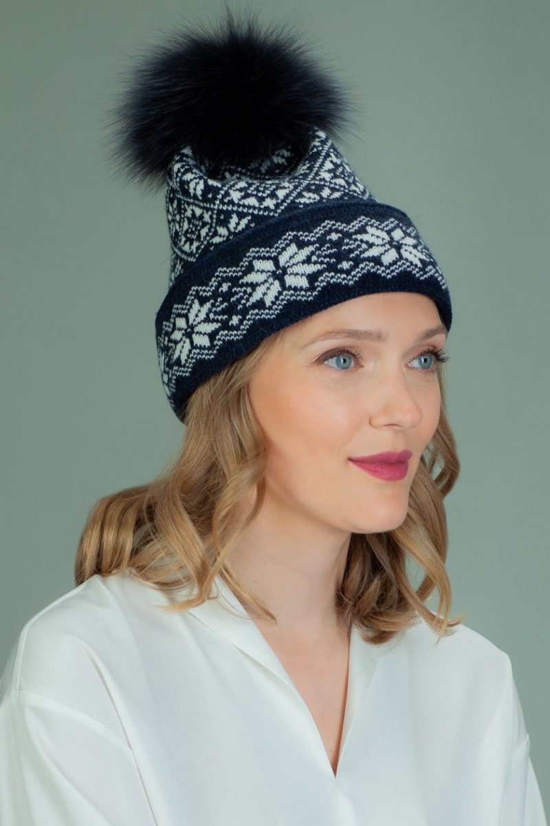 wool hat with fur pom-pom in white star pattern in dark blue background