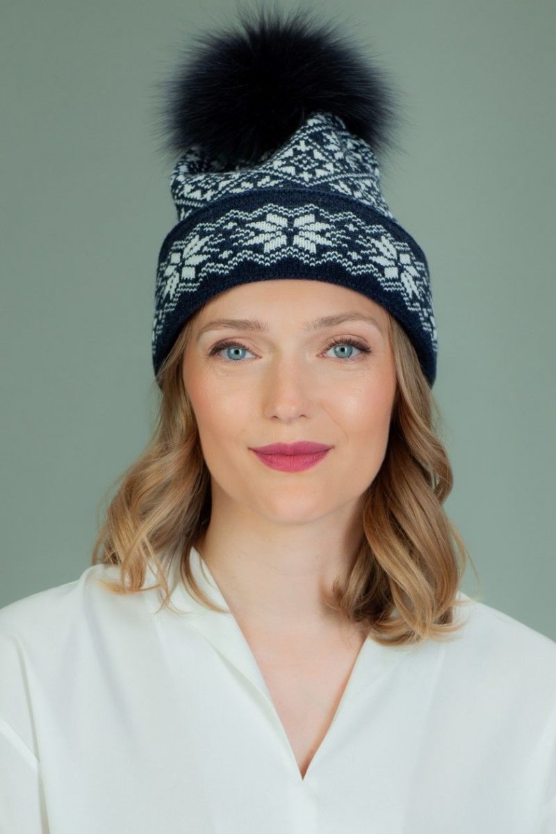 wool hat with fur pom-pom in white star pattern in dark blue background